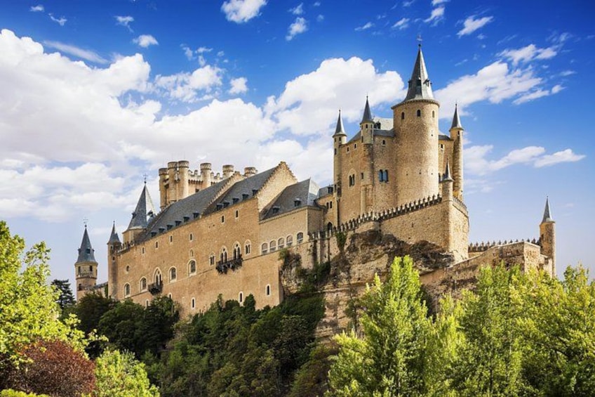A historic castle on a hill with multiple towers and a clear sky. 2