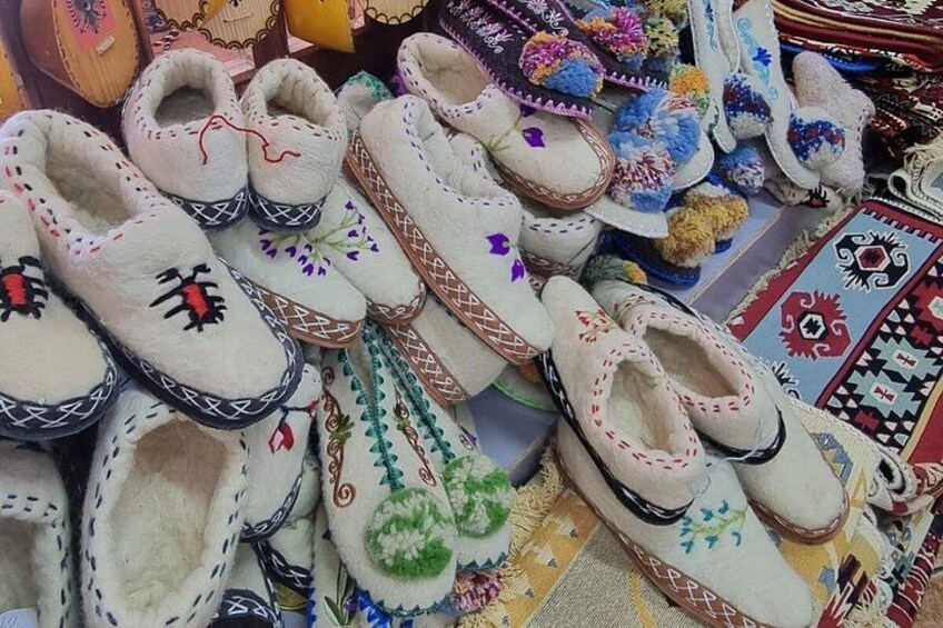 A variety of handmade slippers with colorful embroidery and tassels. 3