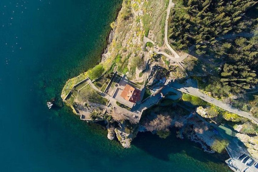 An aerial view of a coastal area with a small island, clear blue water, and a bridge connecting to the mainland. 3
