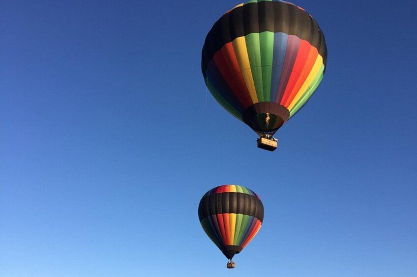 Two hot air balloons against a clear blue sky. 1