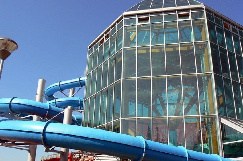 Un edificio de cristal con toboganes de agua azules. 2