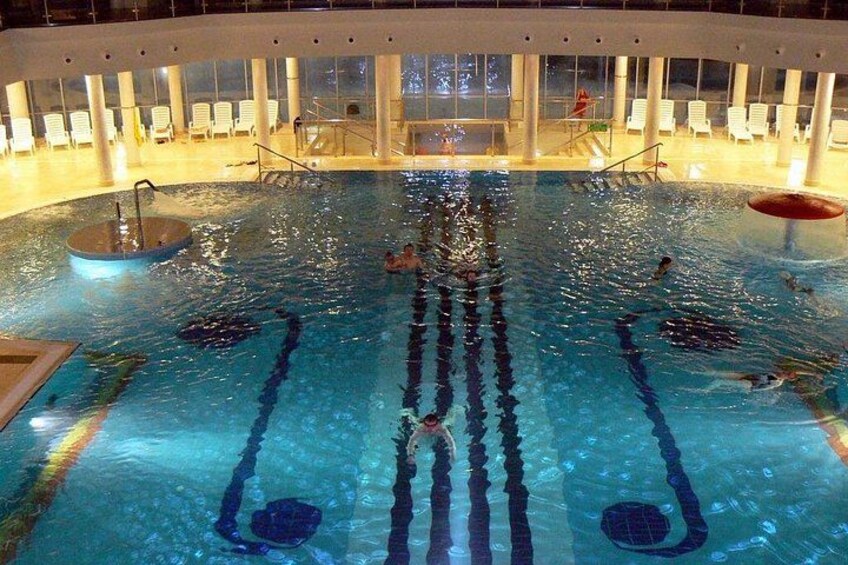 Una piscina con separadores de carriles, sillas de descanso y un puesto de socorristas. 3