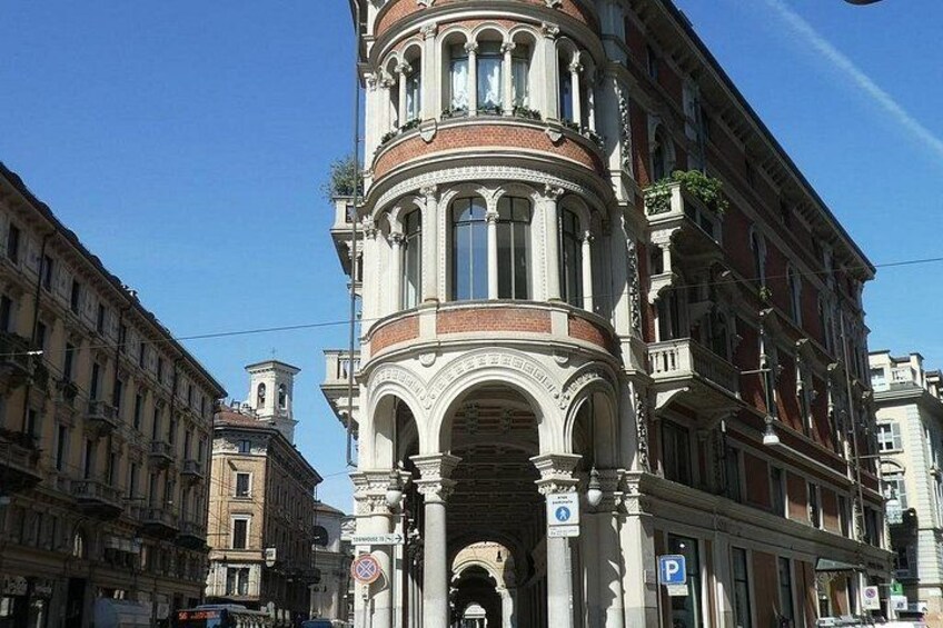 A historic building with ornate architecture, including a prominent arched entrance and decorative balconies. 5