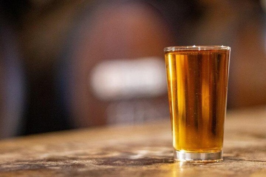 A clear glass of amber liquid on a wooden surface. 3