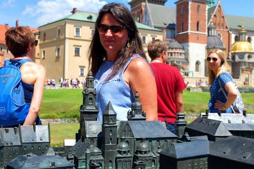 A person standing in front of a model of a historical building. 5