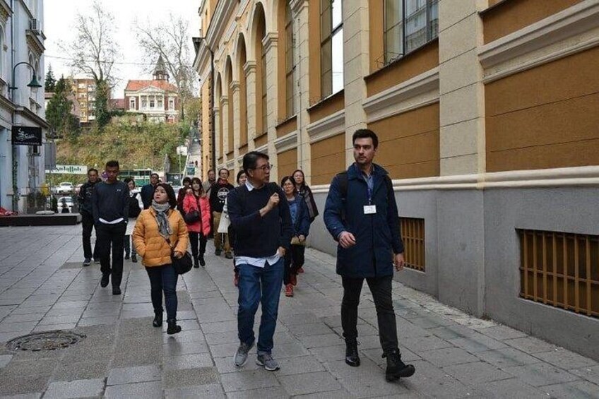 A group of people walking on a city sidewalk. 3