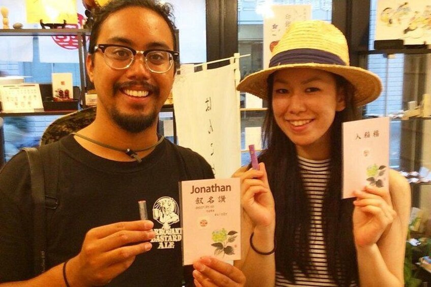 Two people holding books with Japanese text. 2