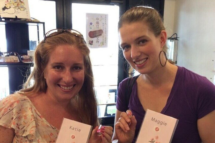 Dos personas sosteniendo libros titulados 'Katie' y 'Maggie'. 1