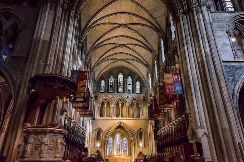 L’intérieur d’une cathédrale, avec de hauts plafonds en voûte, des vitraux et un grand orgue. 4
