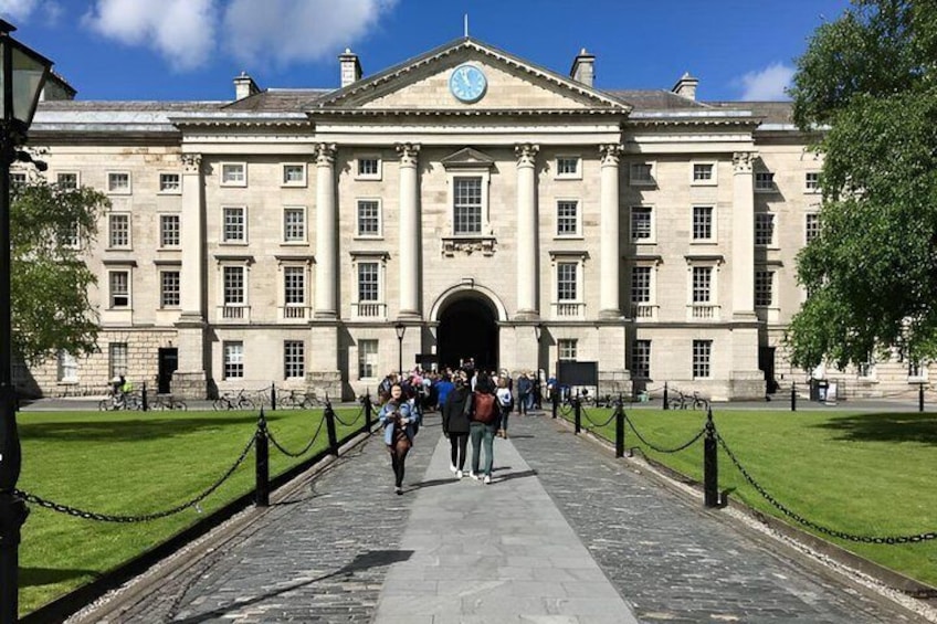 Un grand bâtiment historique doté d’une arche centrale, entouré d’une pelouse bien entretenue et d’un chemin piétonnier dallé. 5