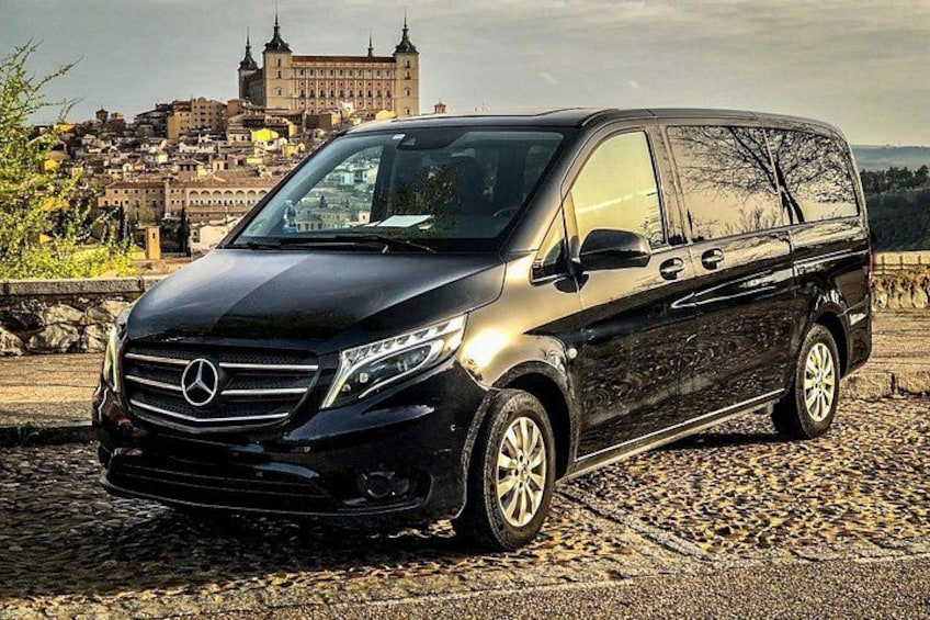 A black Mercedes-Benz Sprinter van parked on a cobblestone surface with a historic building in the background. 2