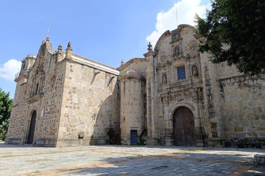 A historic stone building with arched doorways and a large wooden door. 3