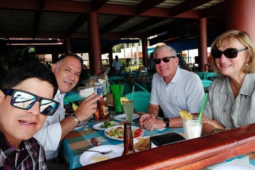 A group of people dining at an outdoor restaurant with a table set for a meal. 5