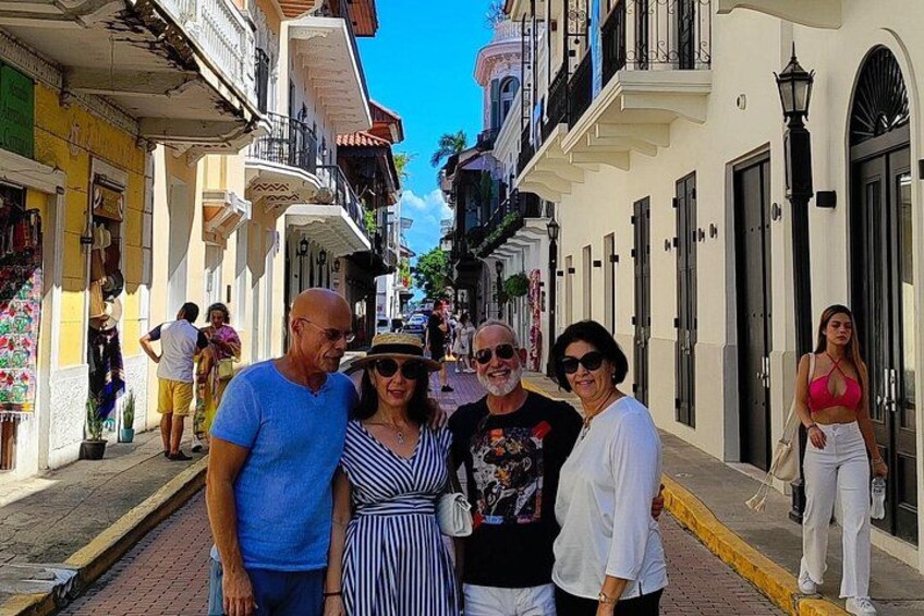 A street with buildings, people, and a clear sky. 1