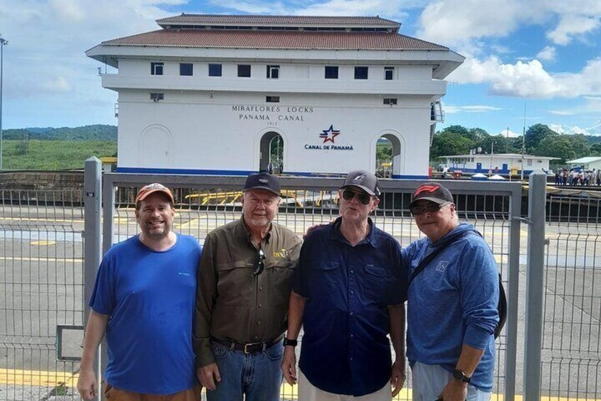 Cuatro hombres de pie frente a un edificio con el letrero 'MIRAFLORES LOCKS CANAL DE PANAMA'. 2