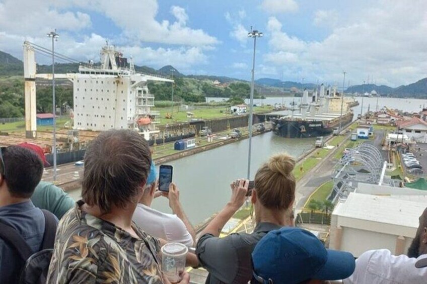 Un río con un puente, edificios industriales y un grupo de personas tomando fotografías. 5