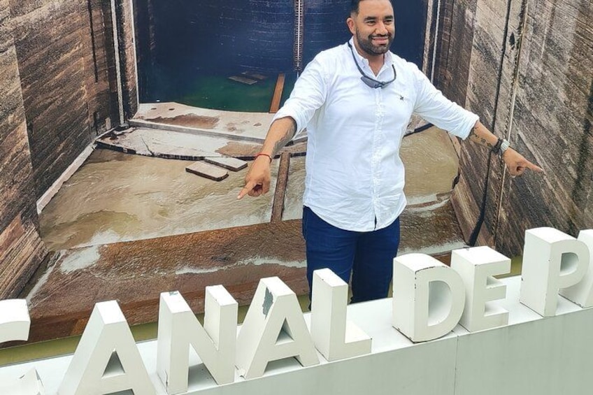 A man pointing at a construction site with a partially built structure and the words 'CANAL DE' visible. 2