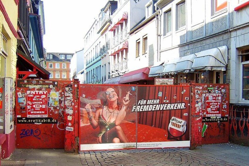 Un panneau publicitaire rouge sur lequel on voit une femme et du texte dans une langue étrangère. 4