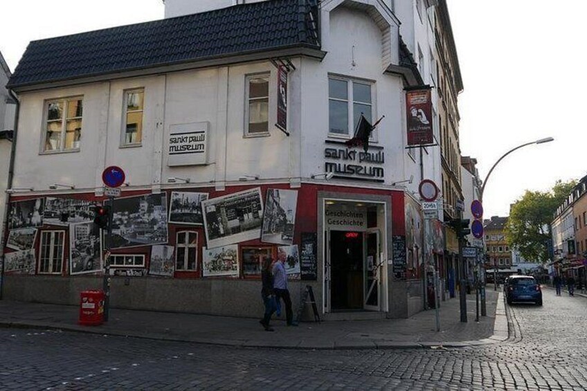 Un edificio con un letrero que dice 'sankt pauli museum' y una calle adoquinada. 4