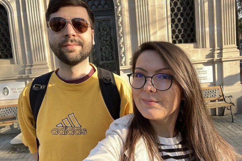 Un homme et une femme prennent un selfie devant un bâtiment à l’architecture classique. 4