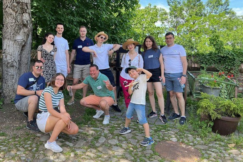 A group of people posing in a garden with trees and potted plants. 4