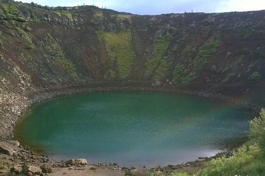 Ein großer Kratersee, umgeben von steilen, felsigen Klippen. 3