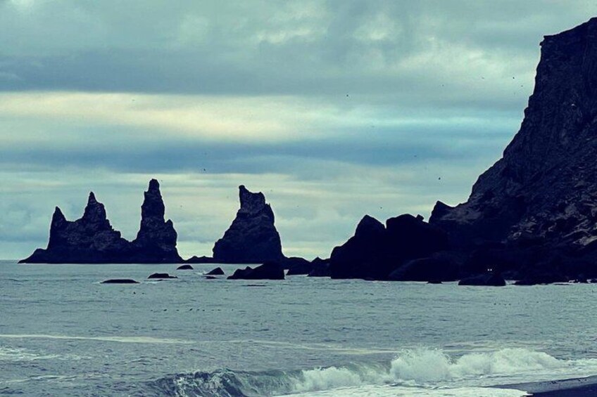 Un paisaje costero con formaciones rocosas destacadas y un cielo nublado. 4