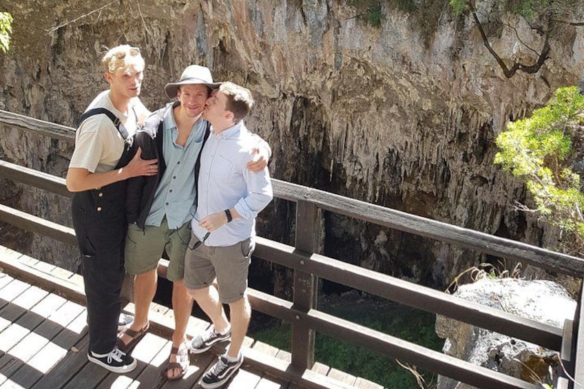 Tres personas sobre un puente de madera, con un risco rocoso al fondo. 5