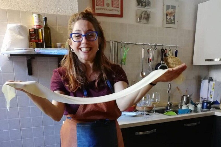 Une personne tenant un objet long et fin dans une cuisine. 1