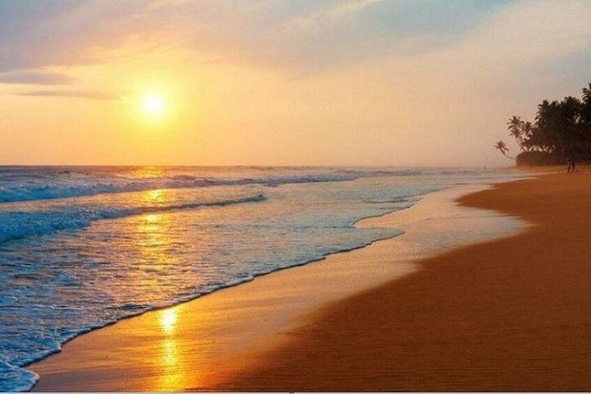 Una playa al atardecer con el sol reflejado en el agua y la arena. 3