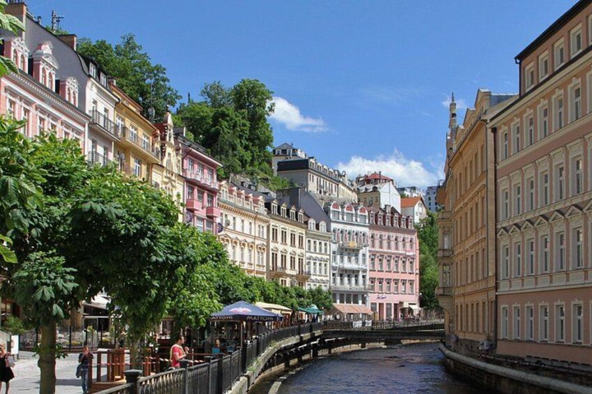 A river with buildings on both sides, a bridge, and trees. 2