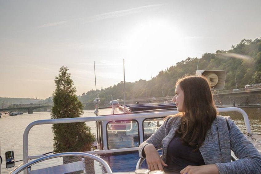 A woman on a boat with a view of a river and a bridge in the background. 2
