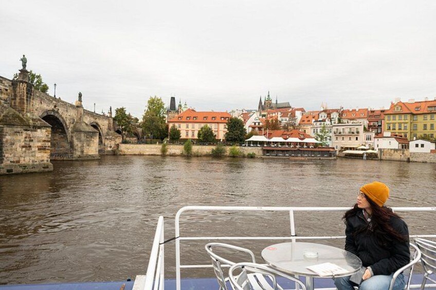Una persona su una barca, un ponte di pietra e edifici lungo un fiume. 3