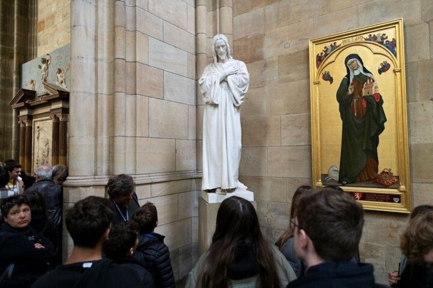 En staty i en kyrka, omgiven av en stor folkmassa. 3