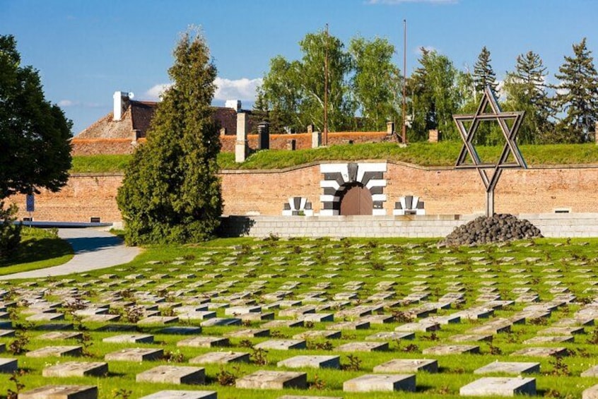 Un cimetière avec de nombreuses tombes, une étoile de David et un bâtiment en arrière-plan. 1