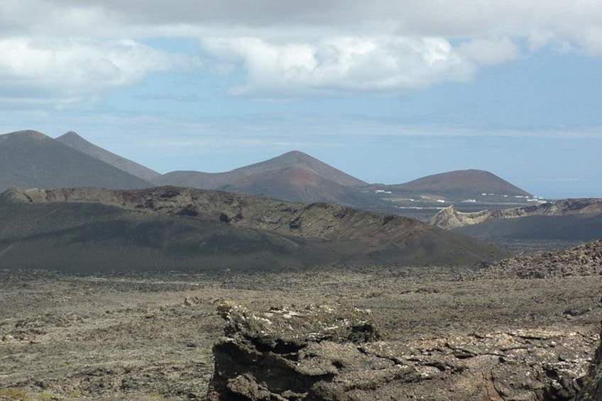 Un paysage volcanique aux reliefs accidentés, avec des montagnes qui se dessinent à l'horizon. 2