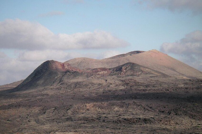 A volcanic landscape with two prominent peaks and a barren terrain. 5