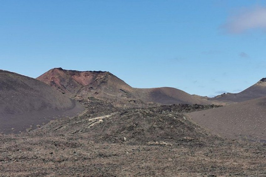 A barren landscape with a prominent hill and a small mound in the foreground. 3