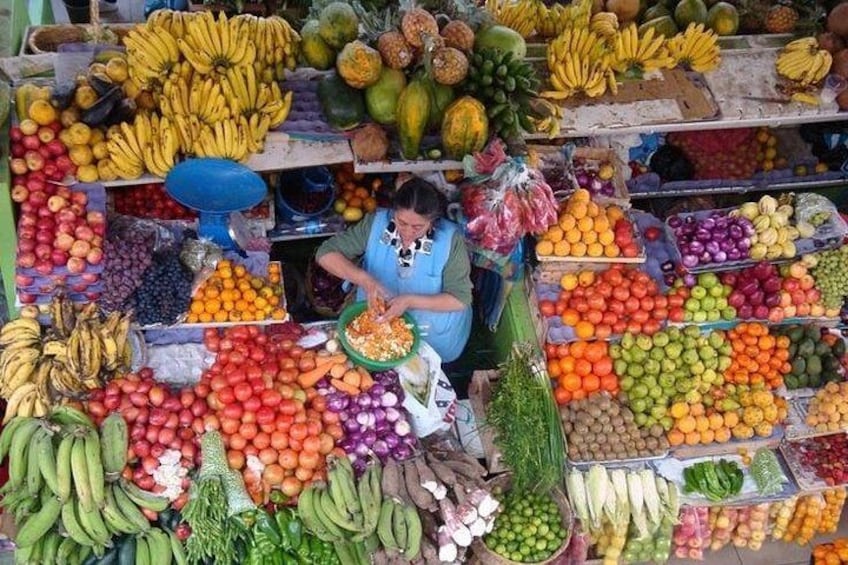 A fruit market with various fruits displayed in baskets and on shelves. 2