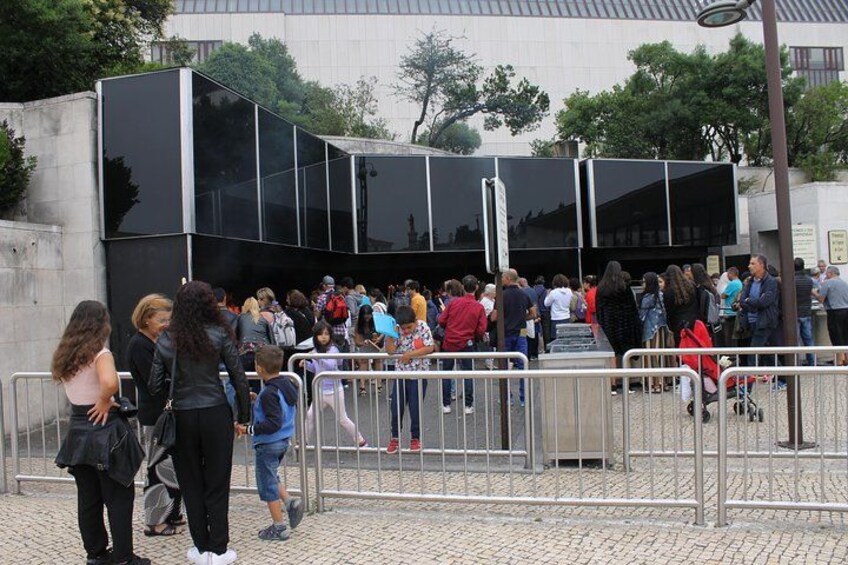 Une foule s'est rassemblée devant un bâtiment moderne doté de grandes fenêtres en verre. 3