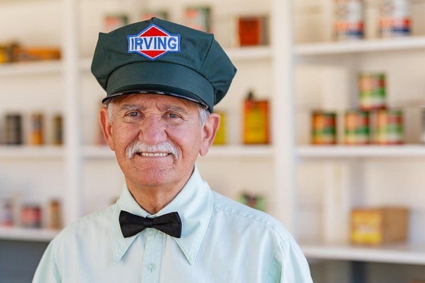 A person wearing a cap with the IRVING logo, a light blue shirt, and a black bow tie. 2