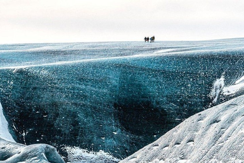 Un paysage gelé où l’on aperçoit un groupe de personnes au loin. 3