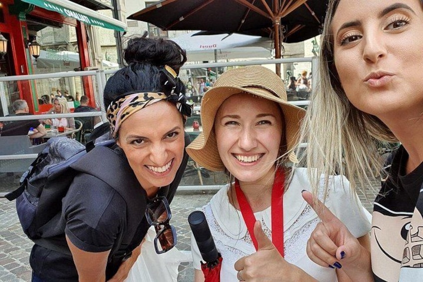 Three people outdoors, one wearing a hat and a lanyard, another with a backpack, and a third with a ponytail. 2