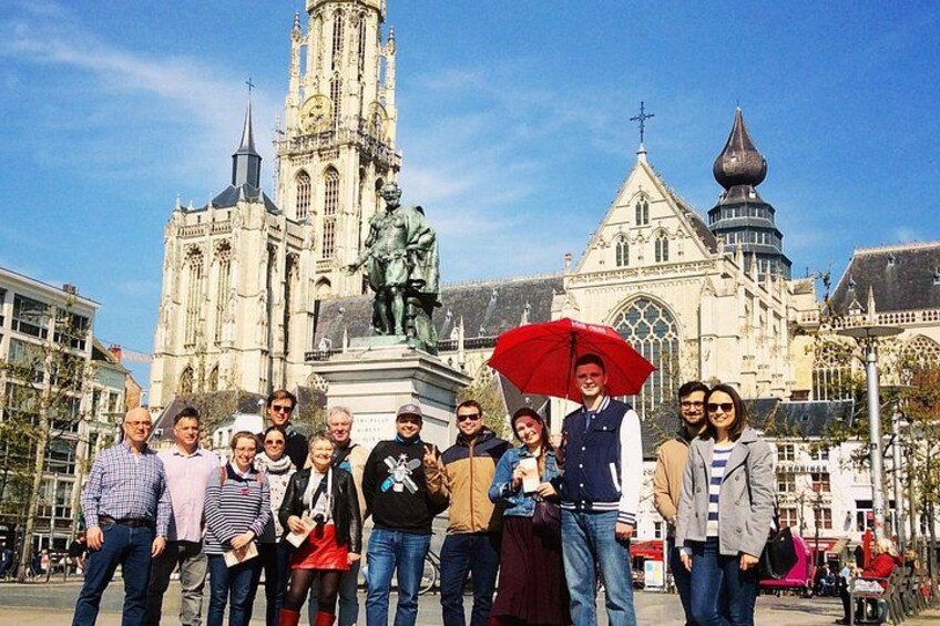 A group of people standing in front of a large cathedral with a statue in the center. 2