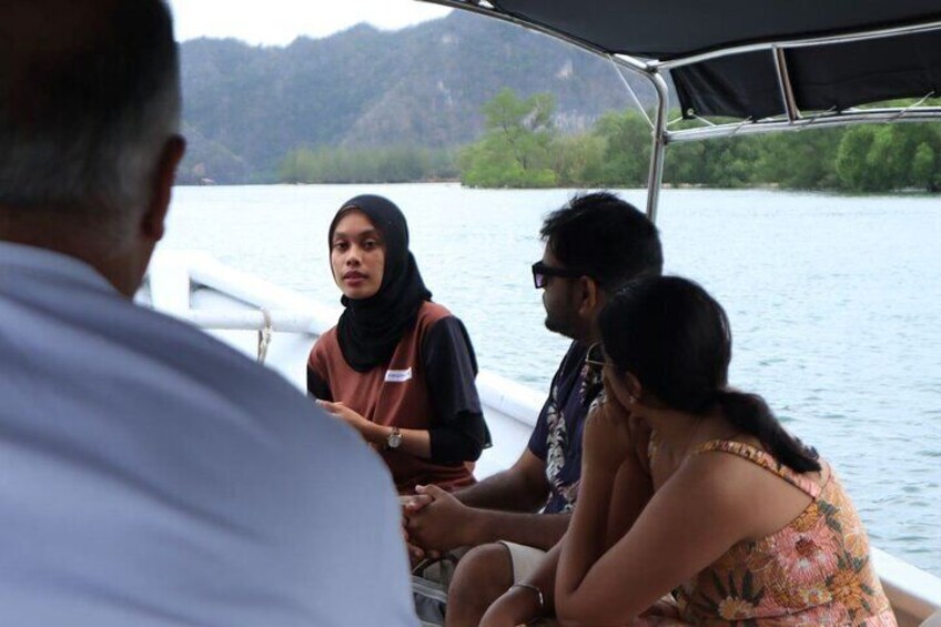 A group of people on a boat with a lake and hills in the background. 4