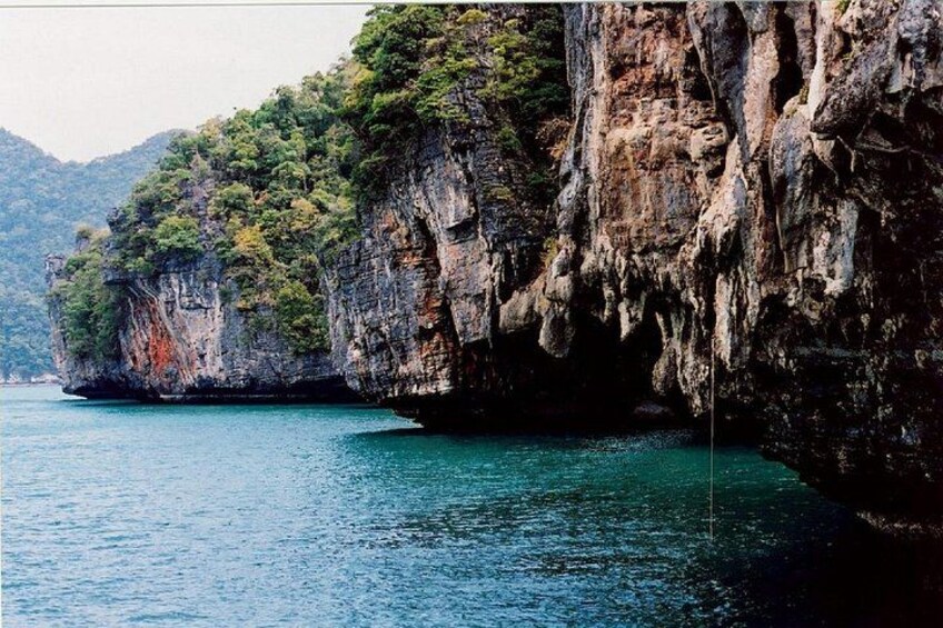 A coastal landscape with rocky cliffs and a calm sea. 1