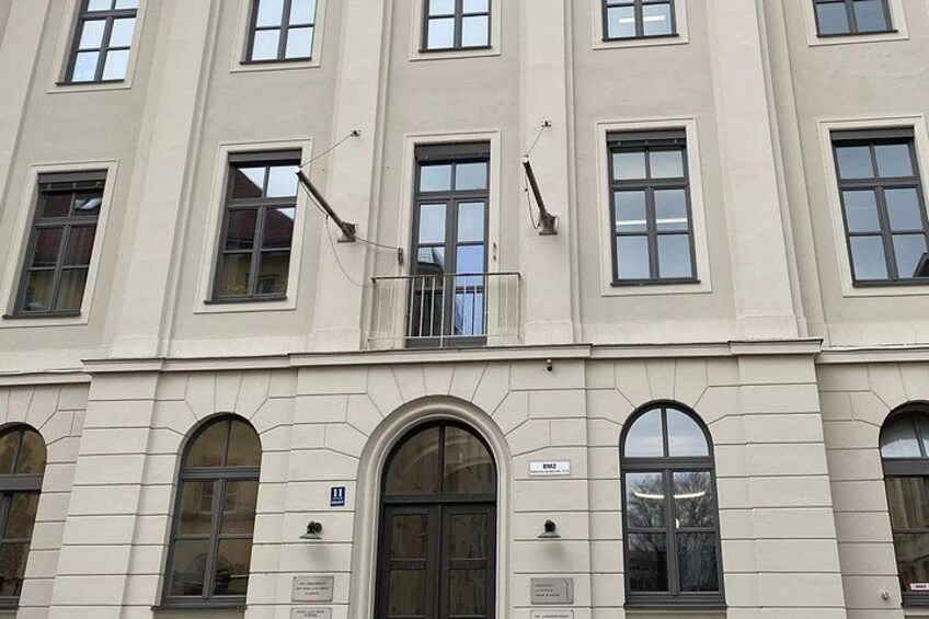 A multi-story building with arched windows and a central entrance. 4