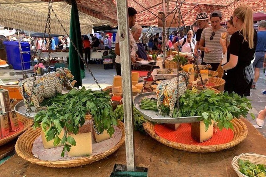 A market stall with fresh produce and a hanging cow decoration. 2