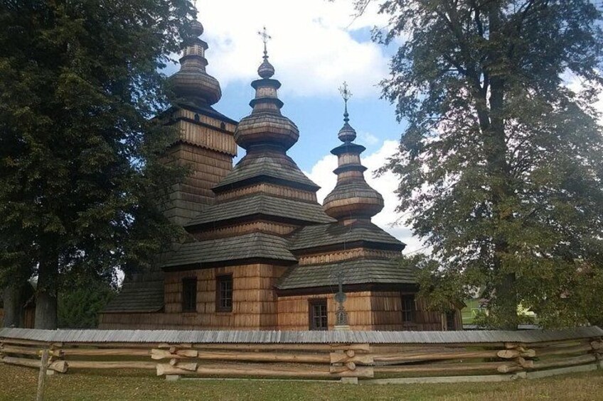 A wooden church with multiple onion-shaped domes and a cross on top. 1