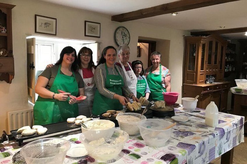 A group of people in a kitchen preparing food, with various cooking utensils and ingredients on the table. 5